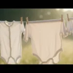 Delikatne ubranka niemowlęce wiszczące na sznurze do wysuszenia, łagodne naturalne oświetlenie, miękkie zapachy i czystość